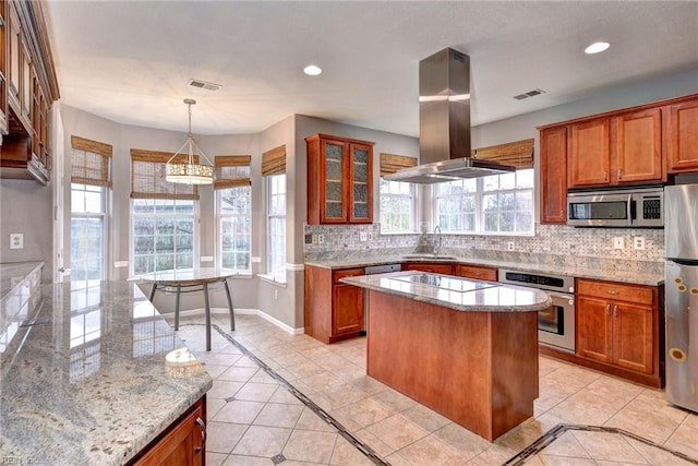 kitchen with a center island, sink, appliances with stainless steel finishes, light stone counters, and island exhaust hood