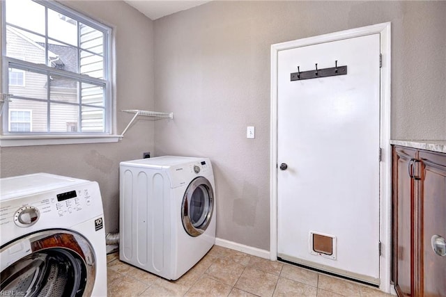 laundry room with independent washer and dryer and light tile patterned floors