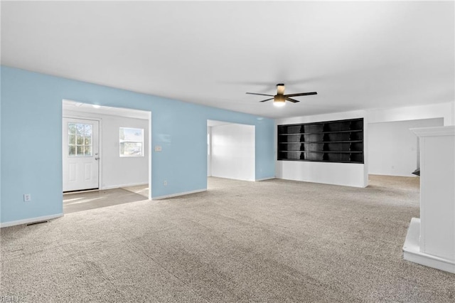 unfurnished living room with ceiling fan and light colored carpet