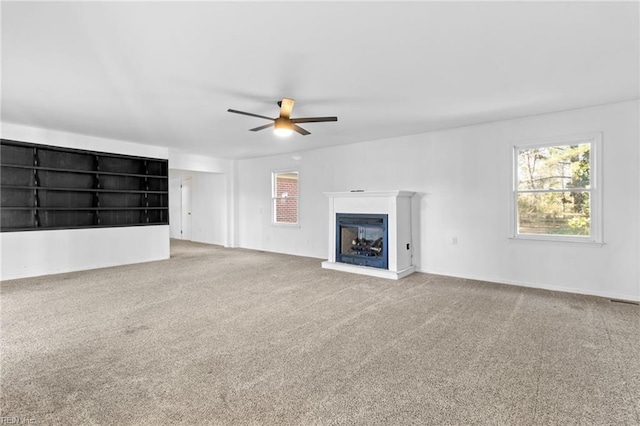 unfurnished living room with ceiling fan and carpet floors