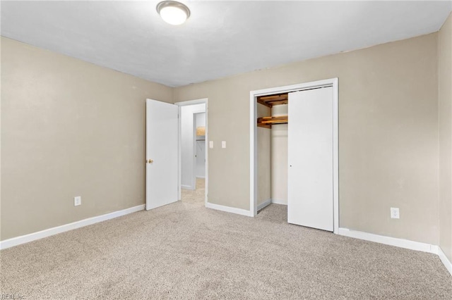 unfurnished bedroom with light carpet and a closet