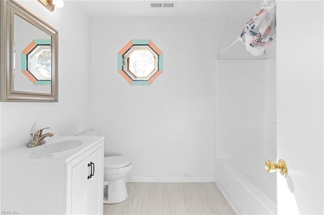 bathroom featuring vanity, a bathtub, and toilet