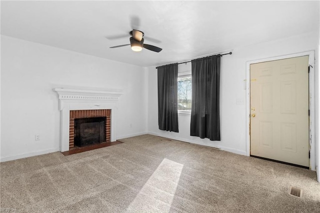 unfurnished living room featuring ceiling fan, light carpet, and a brick fireplace