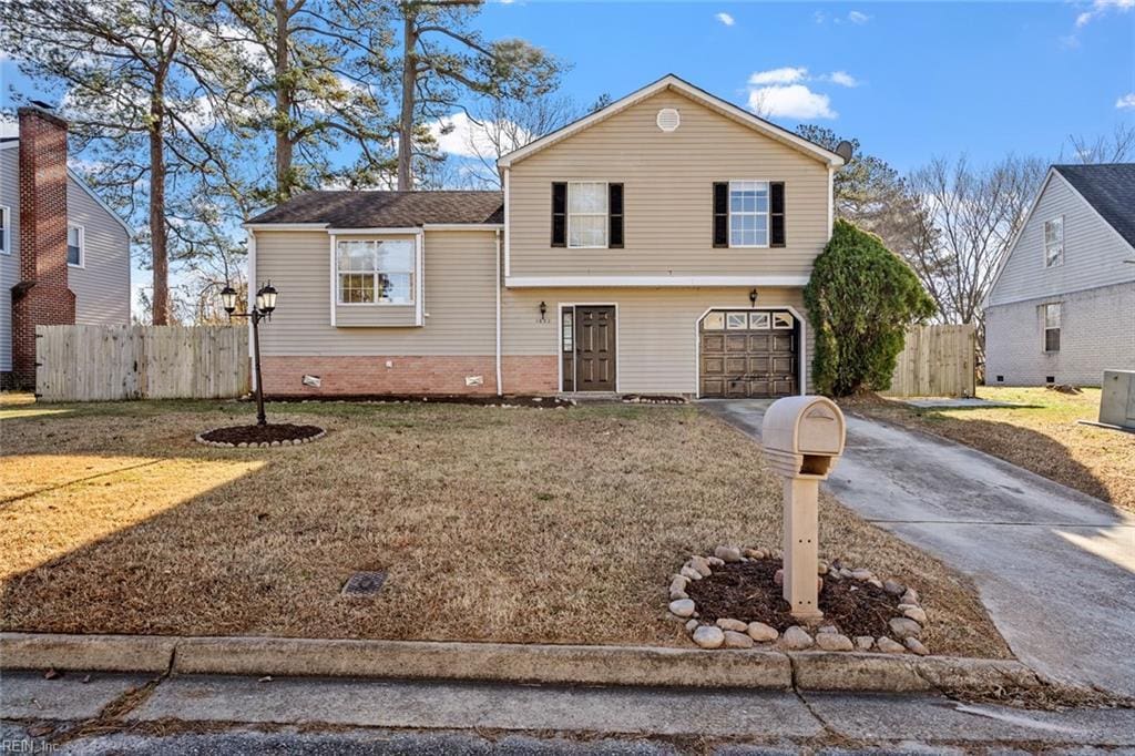 tri-level home featuring a front yard and a garage