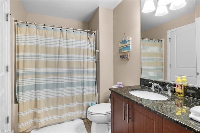 bathroom featuring curtained shower, vanity, and toilet