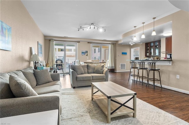 living room featuring ceiling fan, dark wood-type flooring, and track lighting