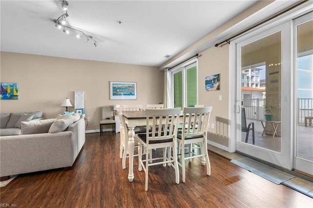 dining space featuring plenty of natural light and dark wood-type flooring