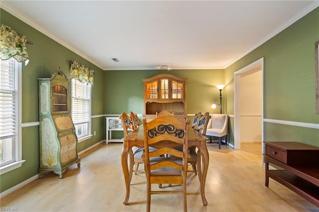 dining area featuring light hardwood / wood-style floors and ornamental molding