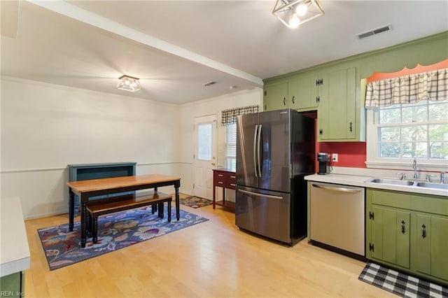 kitchen with a healthy amount of sunlight, sink, stainless steel appliances, and green cabinetry