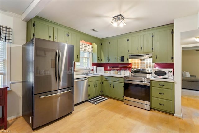 kitchen with appliances with stainless steel finishes, green cabinets, and sink