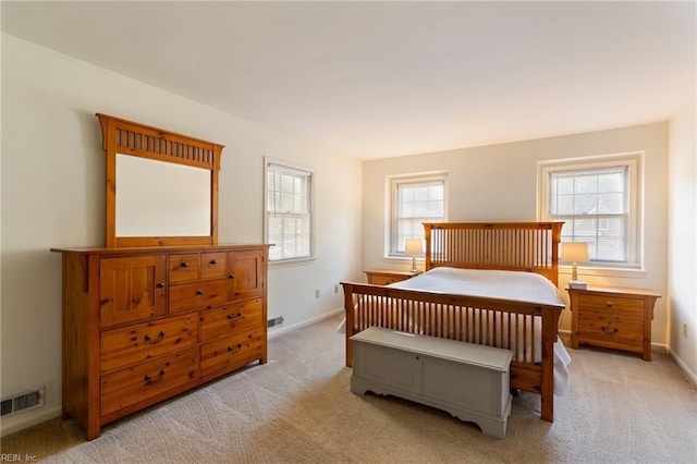 bedroom with light colored carpet and multiple windows