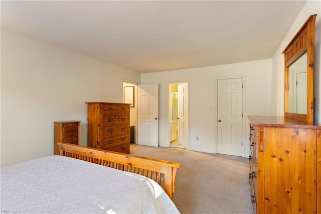 bedroom featuring light colored carpet and connected bathroom