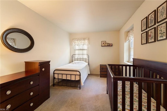 carpeted bedroom featuring a crib and multiple windows