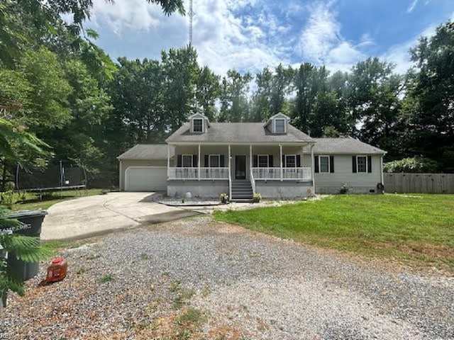 view of front facade featuring a porch, a garage, a trampoline, and a front yard