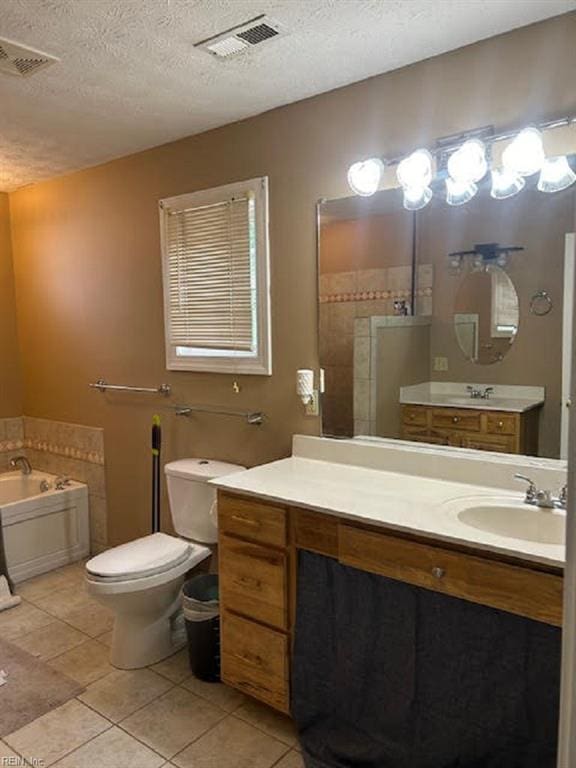 bathroom with tile patterned flooring, vanity, a bath, and a textured ceiling