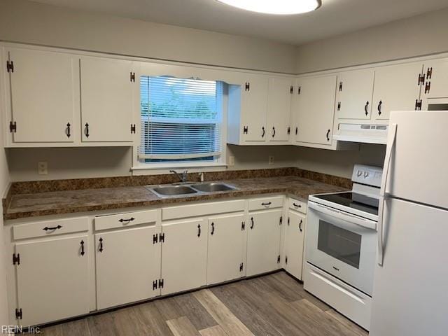 kitchen with white cabinets, hardwood / wood-style floors, white appliances, and sink