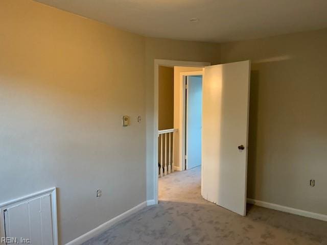 unfurnished room featuring light colored carpet