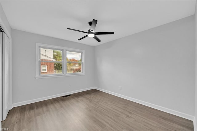 unfurnished bedroom featuring hardwood / wood-style flooring, ceiling fan, and a closet