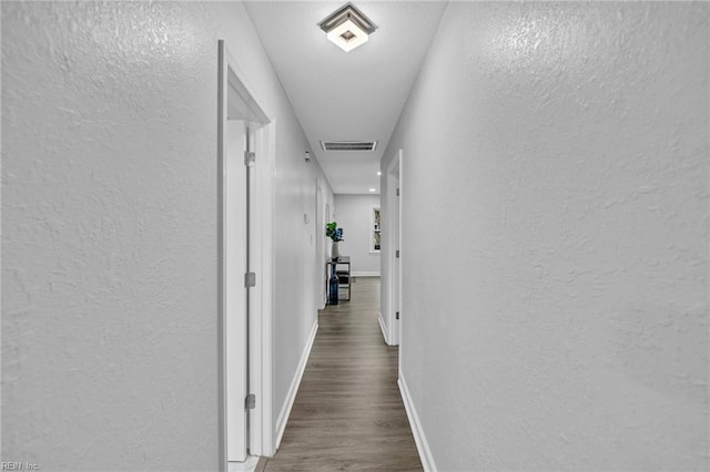 corridor with dark hardwood / wood-style flooring