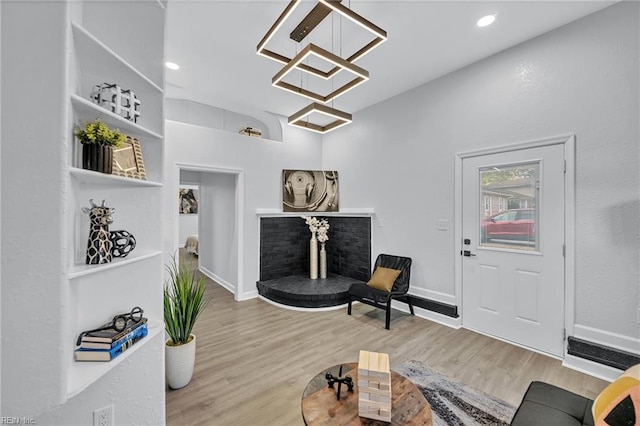 sitting room with hardwood / wood-style flooring, a notable chandelier, and a fireplace