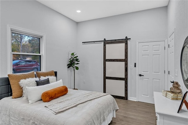 bedroom featuring hardwood / wood-style floors and a barn door