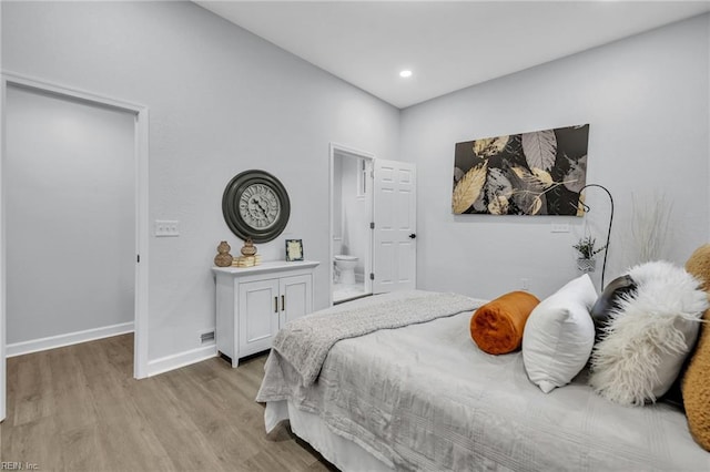 bedroom with ensuite bathroom and light wood-type flooring