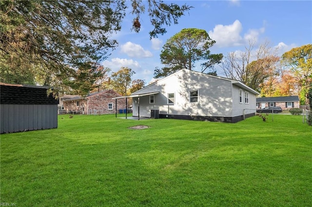 back of property with a yard, a storage unit, and central air condition unit