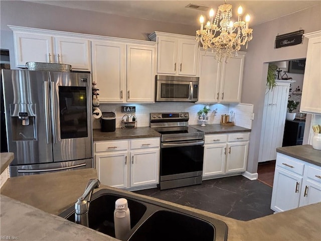 kitchen featuring white cabinetry, sink, stainless steel appliances, decorative light fixtures, and decorative backsplash