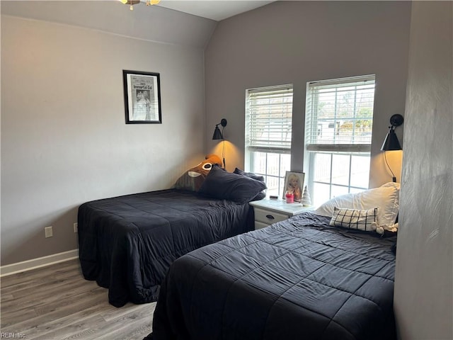 bedroom with wood-type flooring and vaulted ceiling