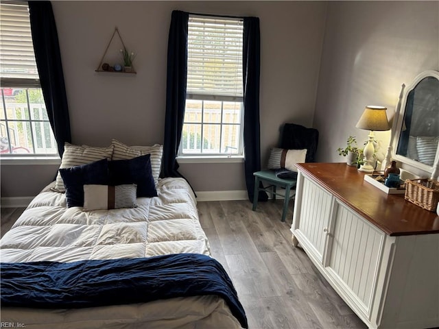 bedroom featuring light hardwood / wood-style flooring and multiple windows