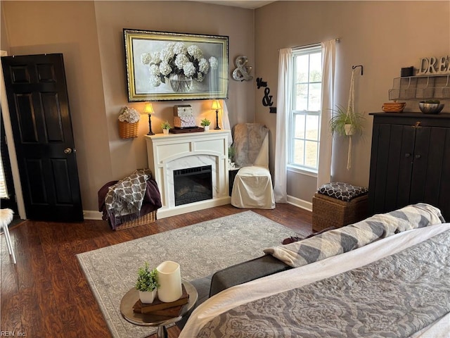 living room with a high end fireplace and dark wood-type flooring