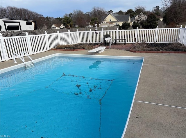 view of swimming pool with a diving board and a patio