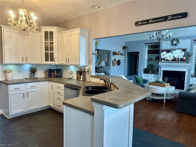 kitchen featuring kitchen peninsula, decorative backsplash, sink, pendant lighting, and white cabinetry