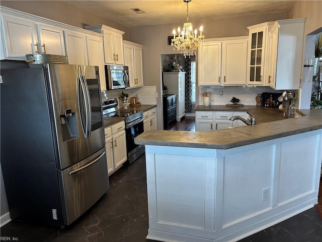 kitchen featuring white cabinets, stainless steel appliances, and hanging light fixtures