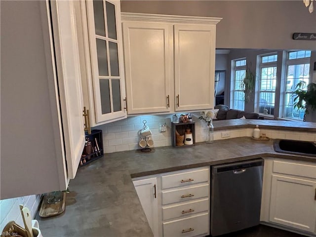 kitchen with backsplash, white cabinets, and stainless steel dishwasher