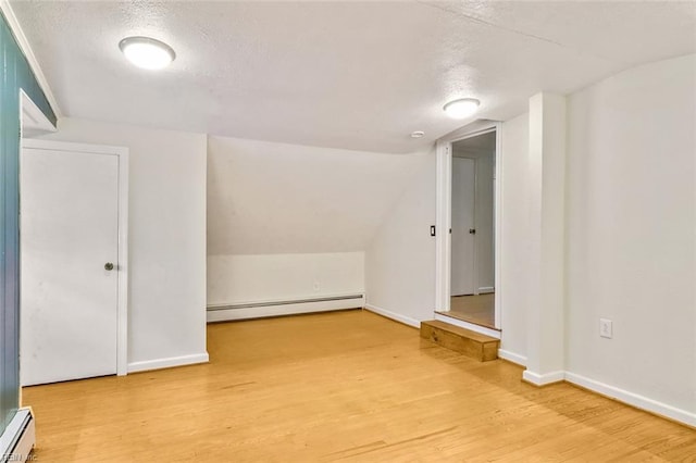 bonus room featuring baseboard heating, lofted ceiling, wood-type flooring, and a textured ceiling