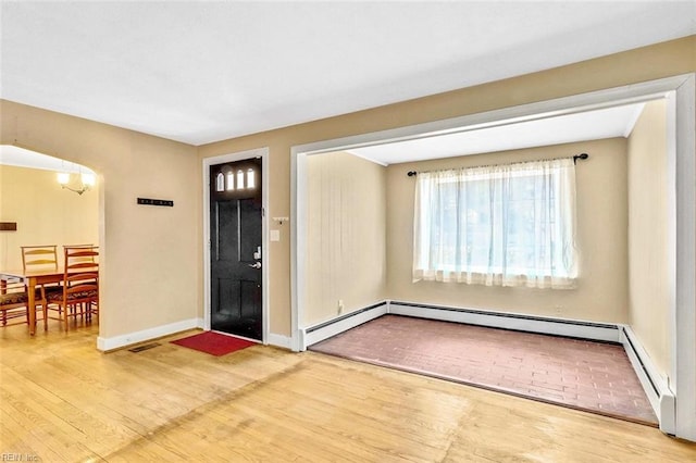 entrance foyer with hardwood / wood-style floors and a baseboard heating unit