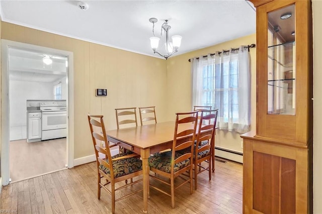 dining space with an inviting chandelier, a wealth of natural light, and light hardwood / wood-style flooring