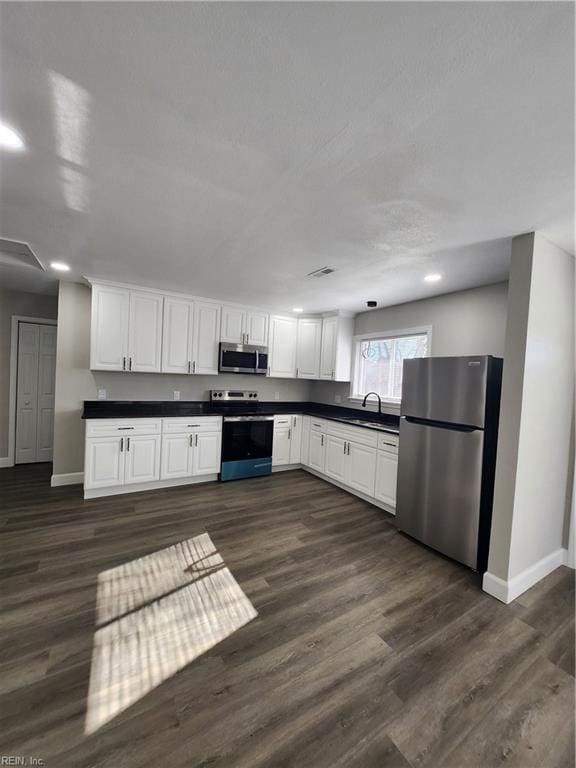 kitchen featuring white cabinets, stainless steel appliances, dark hardwood / wood-style floors, and sink