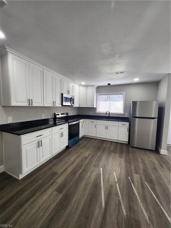 kitchen with white cabinetry, sink, dark wood-type flooring, and appliances with stainless steel finishes