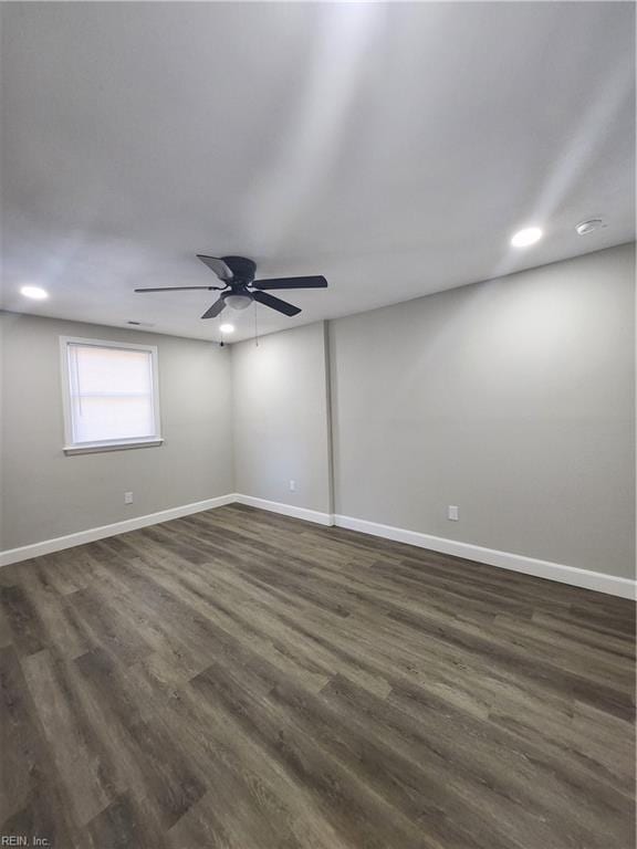 spare room with dark hardwood / wood-style flooring and ceiling fan