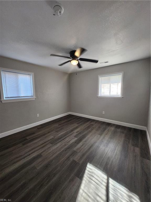 unfurnished room with ceiling fan, dark hardwood / wood-style flooring, and a textured ceiling