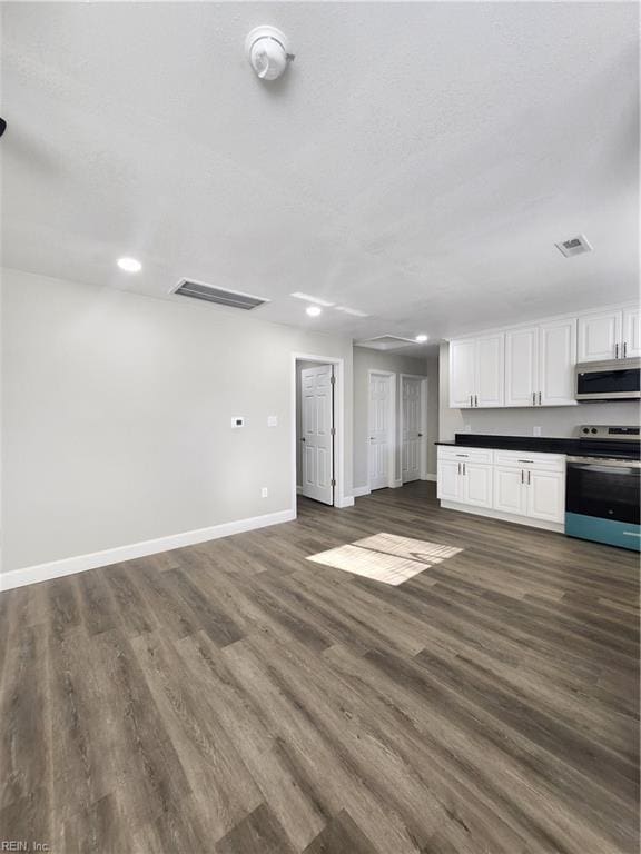 kitchen with dark hardwood / wood-style flooring, white cabinets, and stainless steel appliances