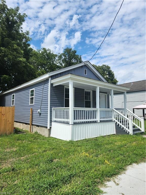 view of front of home with covered porch and a front yard