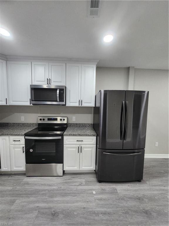 kitchen with white cabinetry, light hardwood / wood-style flooring, and appliances with stainless steel finishes