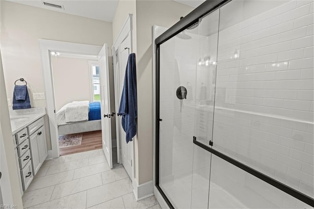 bathroom with tile patterned flooring, vanity, and walk in shower