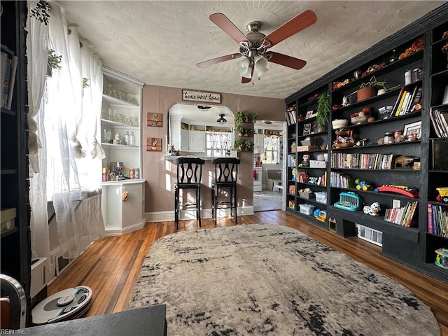 interior space with hardwood / wood-style flooring, ceiling fan, built in features, and a textured ceiling