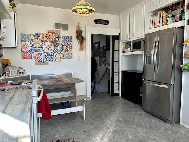 kitchen featuring white cabinetry, stainless steel appliances, and an inviting chandelier