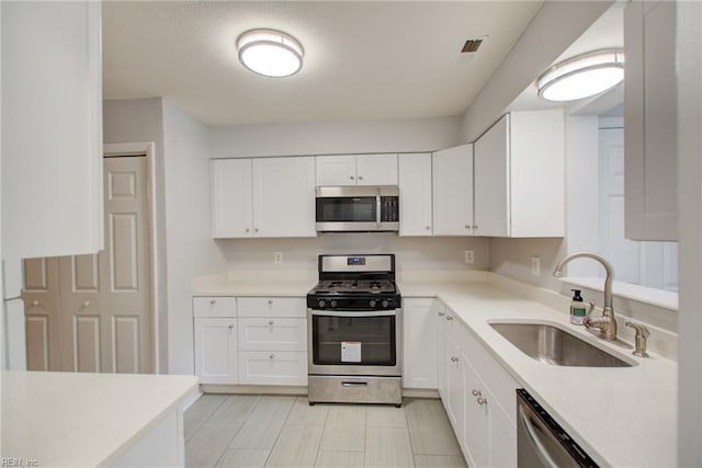 kitchen with white cabinetry, sink, and stainless steel appliances