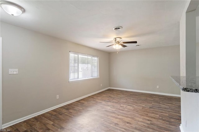 unfurnished room with dark hardwood / wood-style flooring and ceiling fan